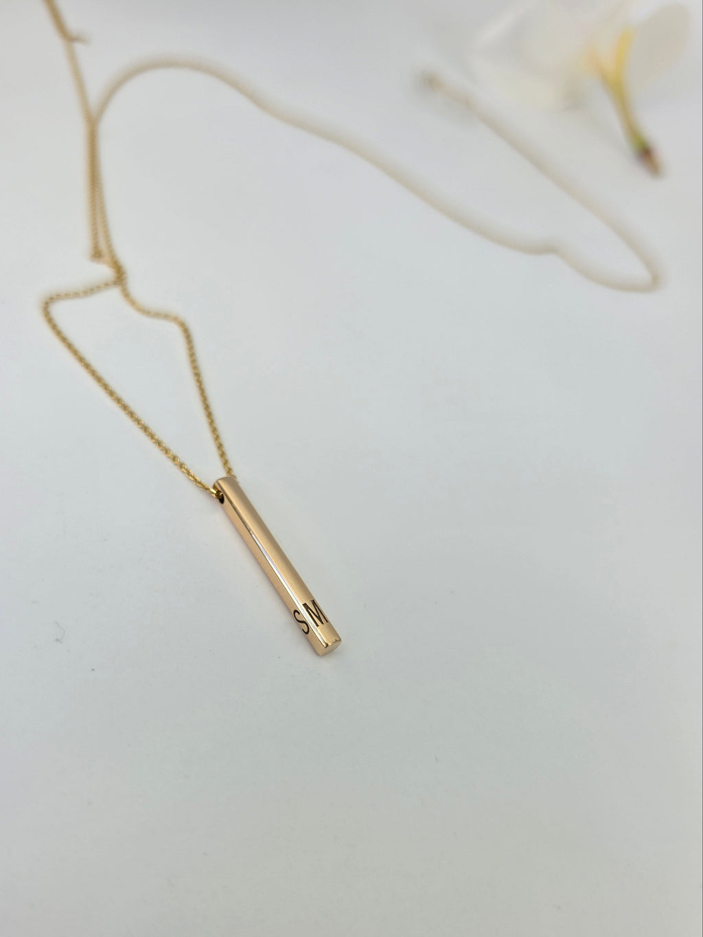 Gold necklace on a light gray background