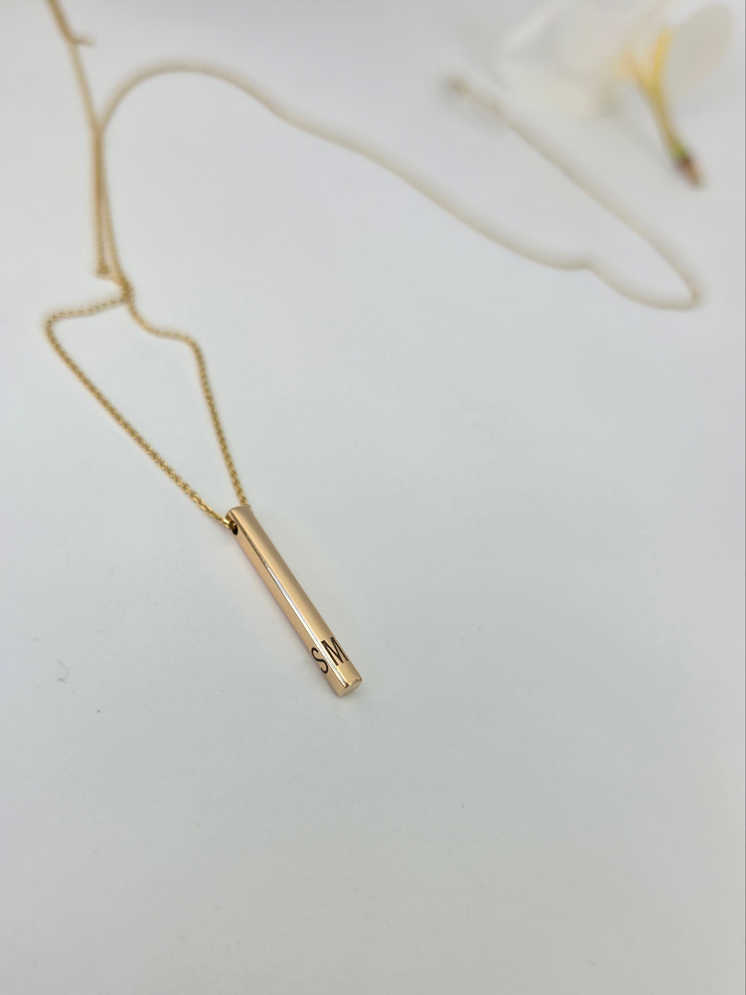 Gold necklace on a light gray background