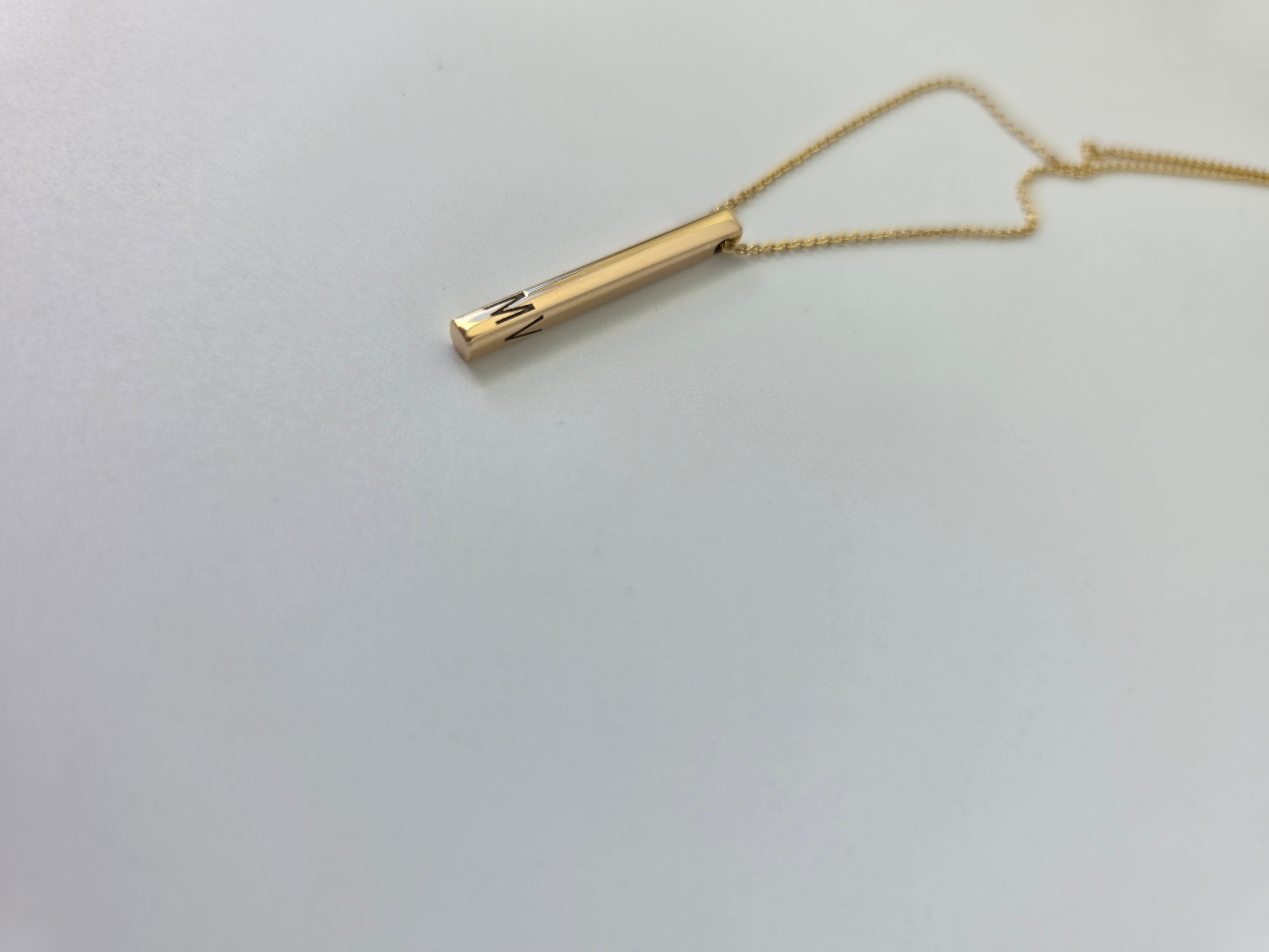 Gold necklace on a light gray background